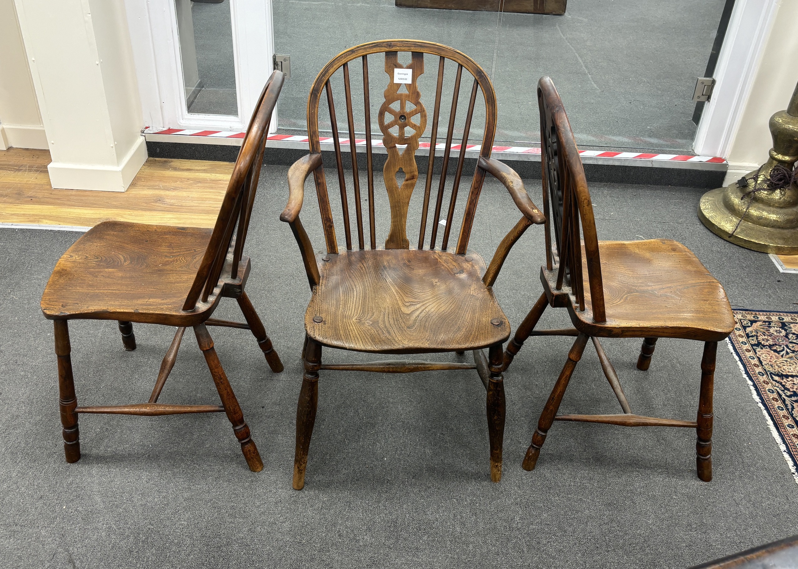 A set of three mid 19th century elm and ash wheel back dining chairs, one with arms